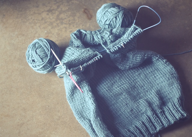 Image of a sweater with both sleeves attached to one long circular needle to be knit at the same time.