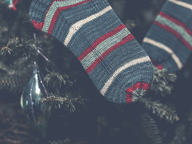 Image of my completed striped Christmas socks hanging from the tree.