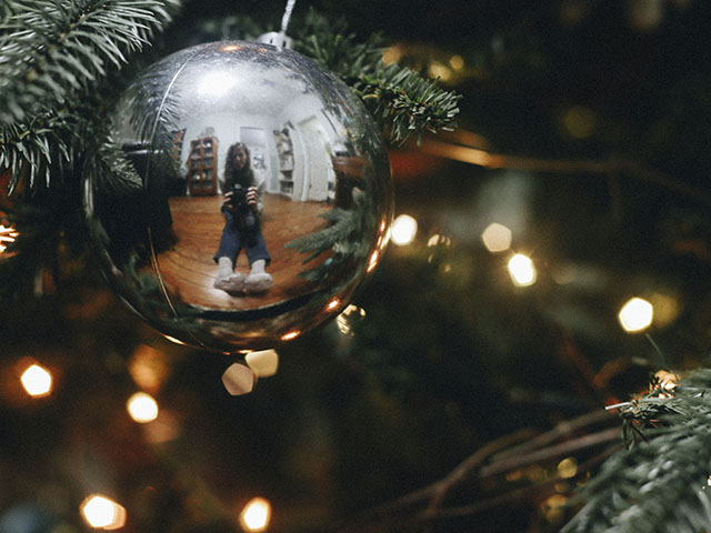 Image of me wearing my Christmas socks reflected in a glass ball ornament.