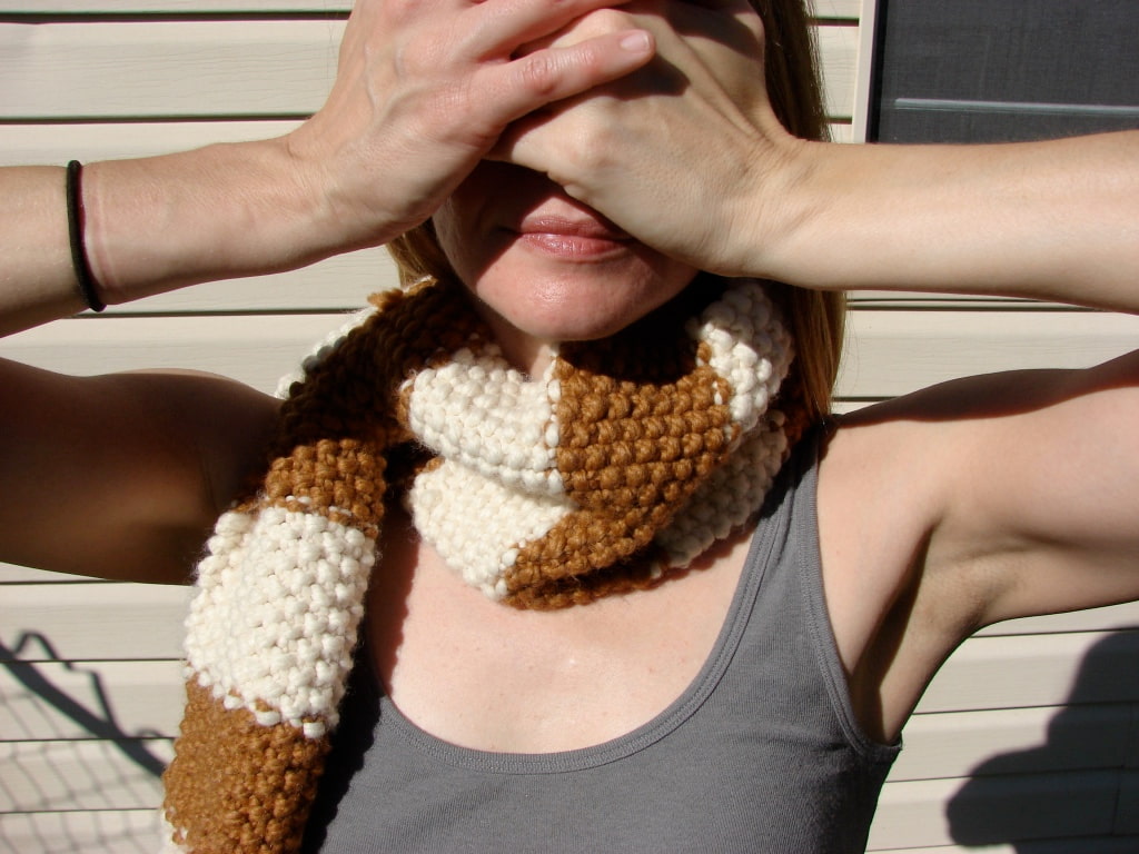 Image of me in one of my first hand knit scarves covering my eyes because the sun is so blinding plus I feel stupid.