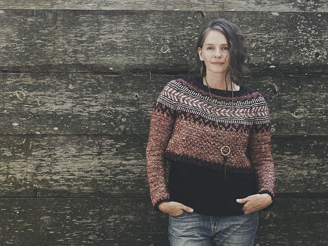 Image of me leaning against an old Acadian barn wall in my Soldotna Sweater.