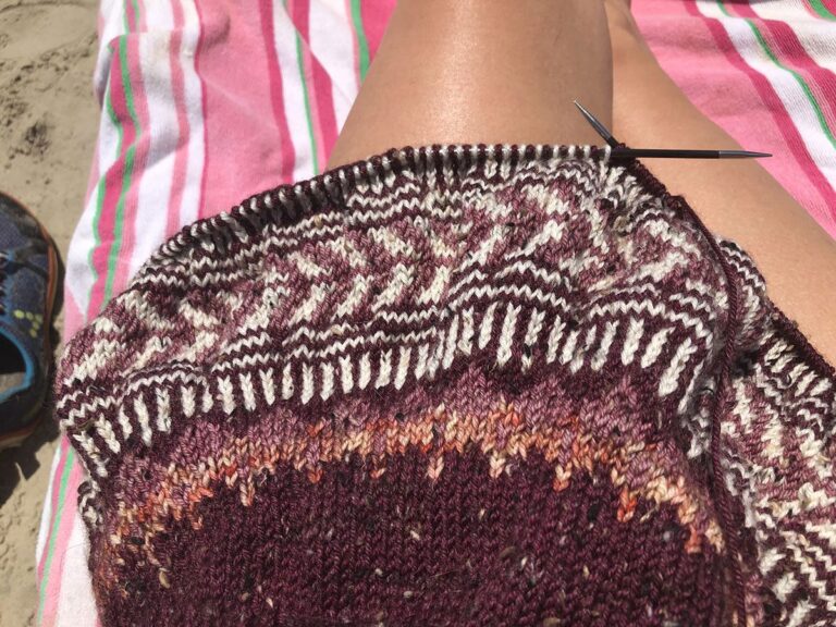 Image of my Soldotna dk sweater on my lap at the beach.