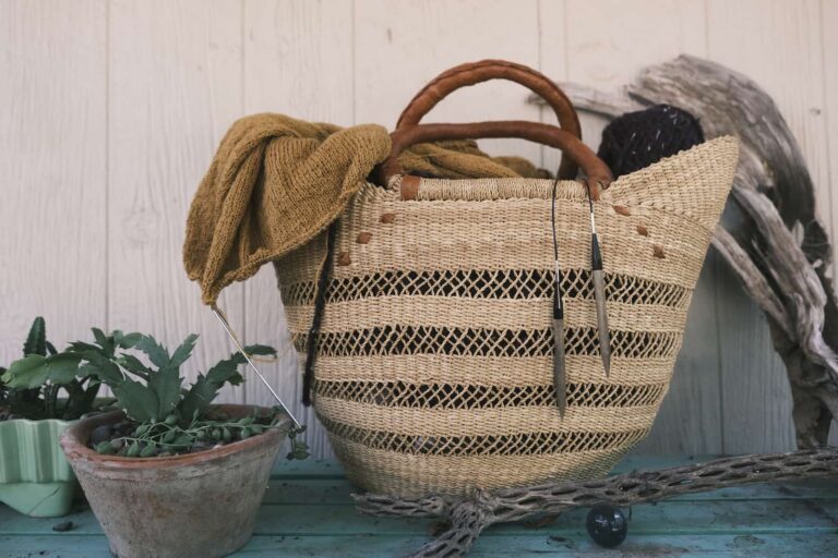 Image of my large knitting basket stuffed with my Fernwood Cardigan and Raw-Tee.