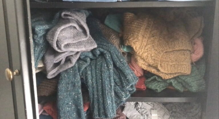 Image of a chaotic, messy sweater shelf.